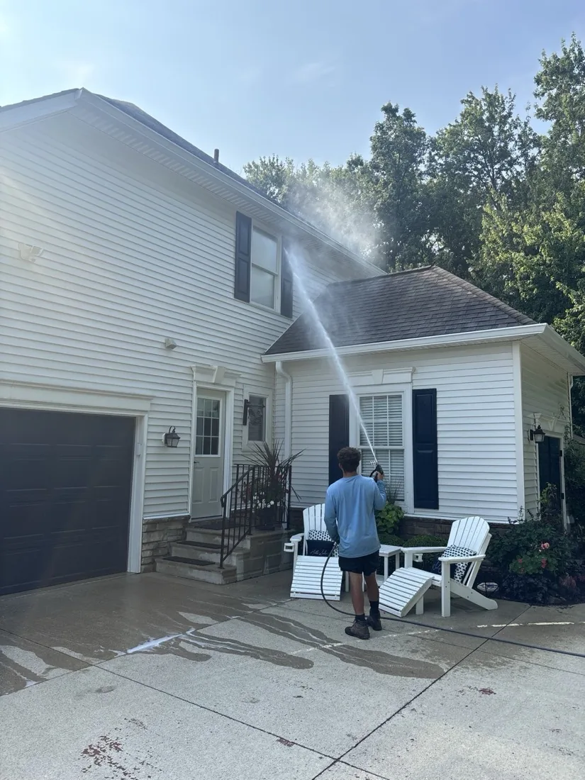 Working the spray along the lower siding and trim