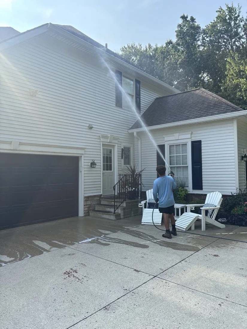 Soft washing the corner of the house at the downspout