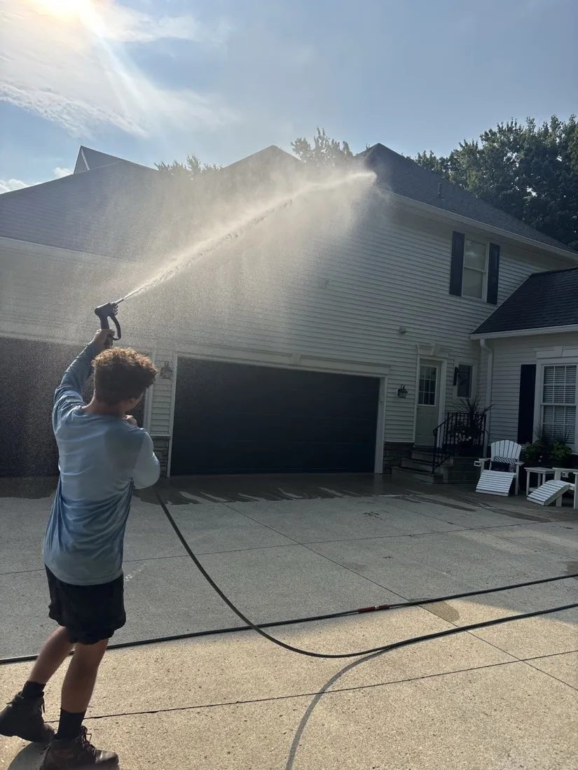 Spray reaching the peak of the gable during a soft wash