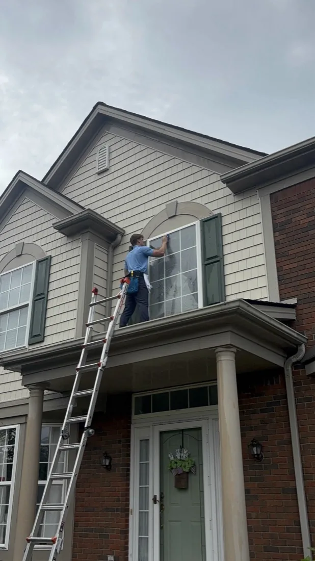 Full view of the ladder reaching an arched second-floor window