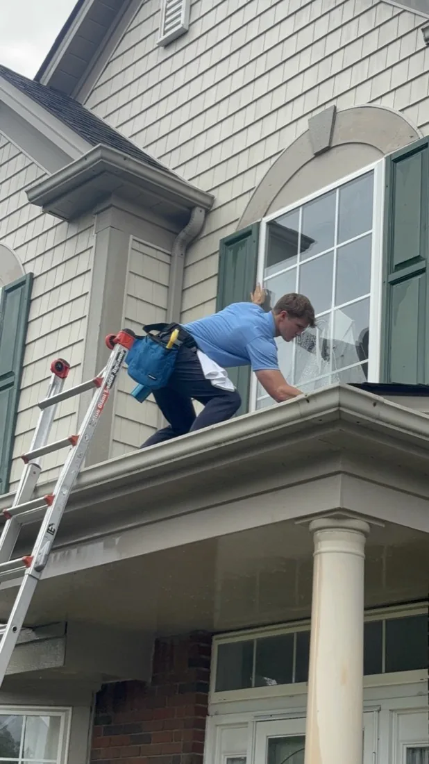 Stepping along the porch roof between upper windows