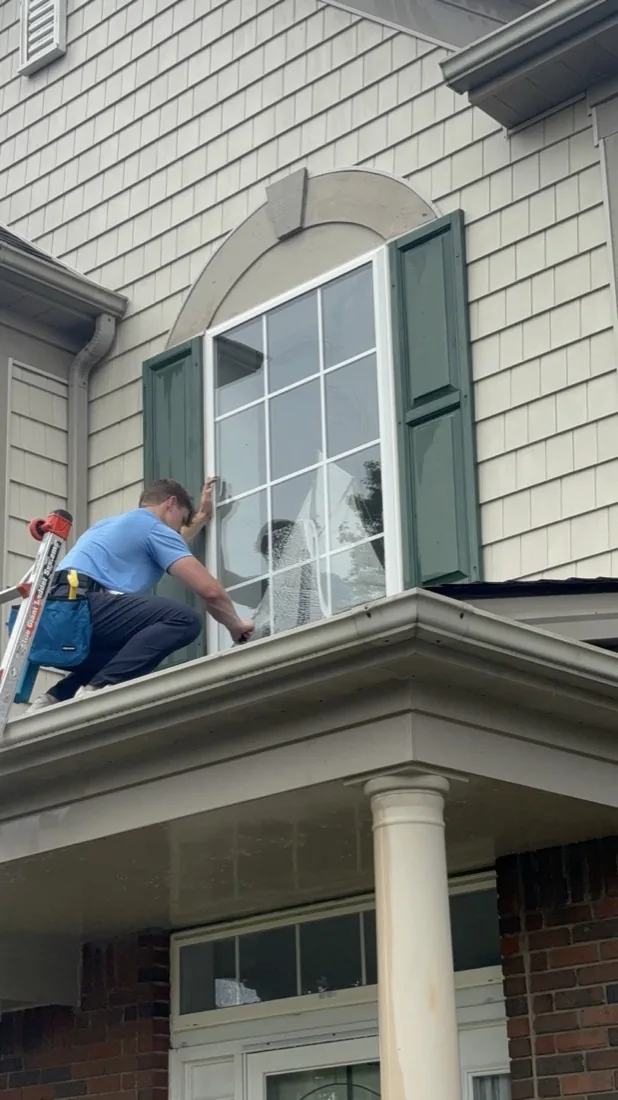 Ladder against the porch roof on a window cleaning job