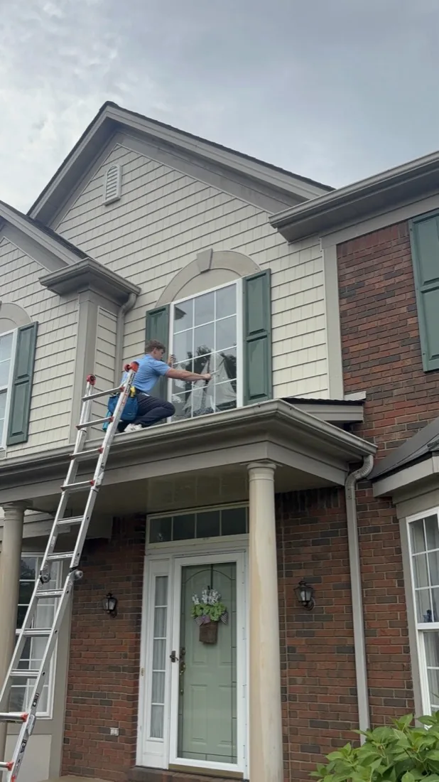 Exterior window cleaning on a brick-and-siding home